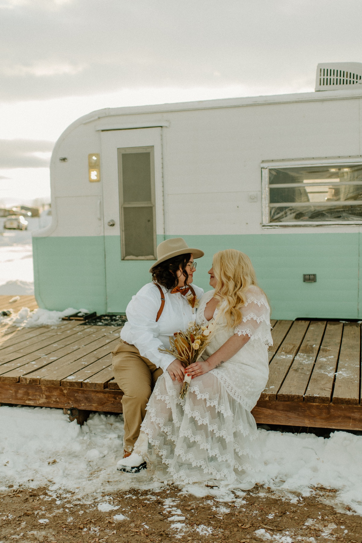 Brides take portraits at sunset outside their vintage camper in Taos New Mexico at the Hotel Luna Mystica