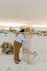 Brides take portraits at sunset outside their vintage camper in Taos New Mexico at the Hotel Luna Mystica