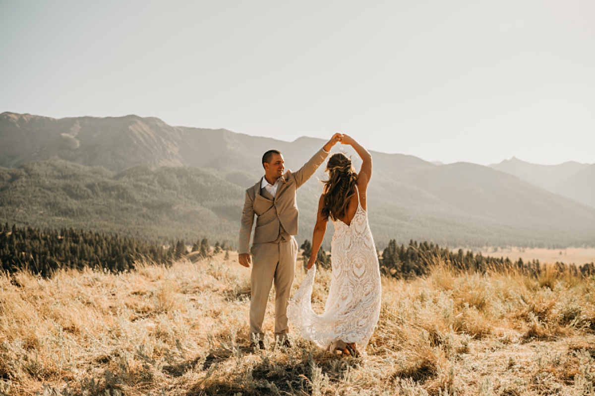 Groom twirls his bride at golden hour in the Wallowa Mountains in Joseph Oregon.