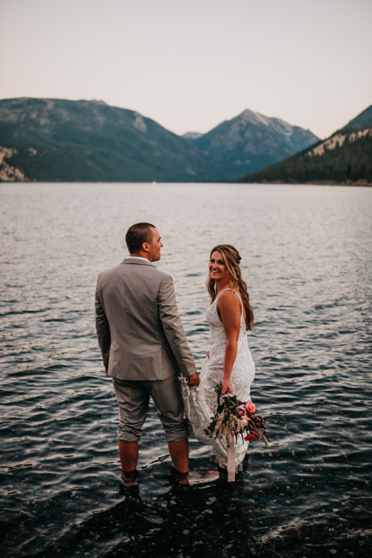 Sunset photos of a bride and groom taking adventure portraits in Wallowa Lake in Joseph Oregon 