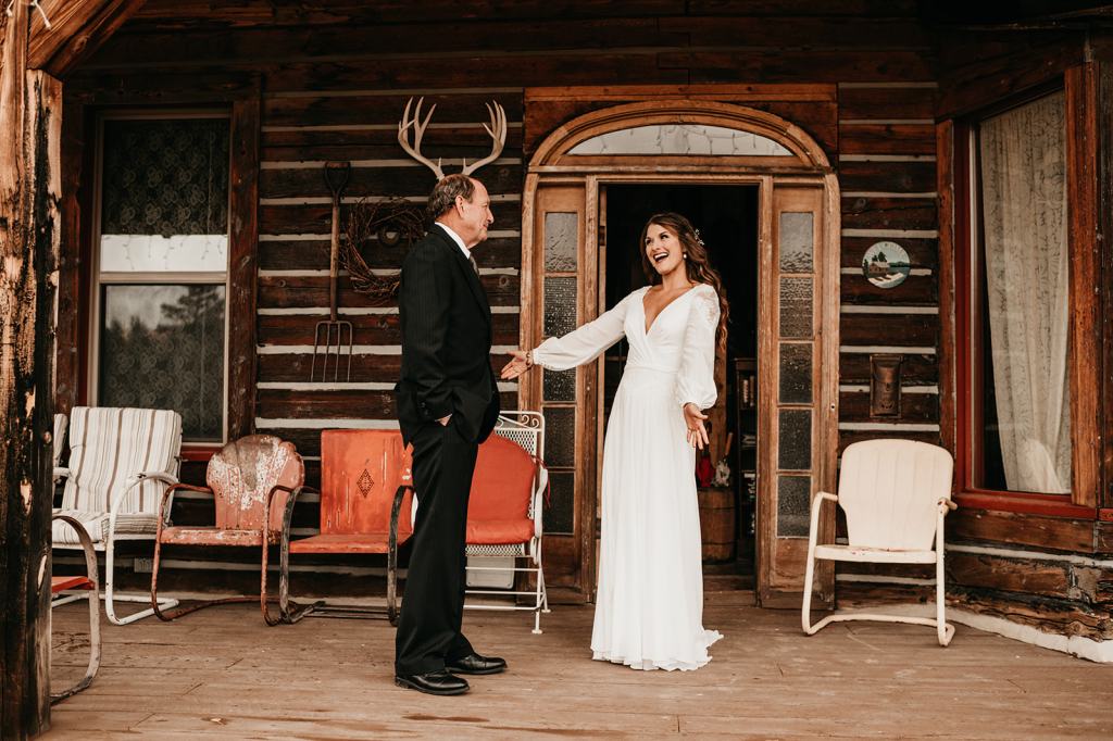 First look between the father of the bride and the bride on the front porch of the cabin in Steamboat Springs Colorado