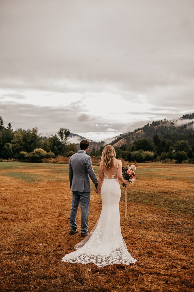 Romantic and moody fall wedding portrait of a bride and groom on their wedding day at the Sixty Chapel in Garden Valley Idaho with mountains behind them