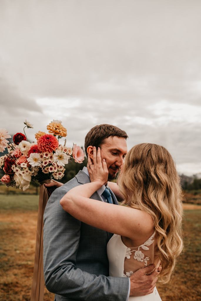 Bride and groom share a romantic moment on their fall wedding day at the Sixty Chapel in Garden Valley Idaho