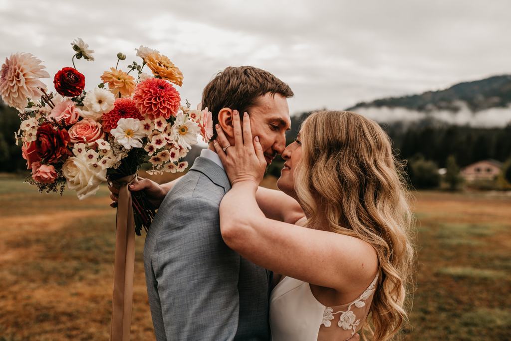 Romantic and moody fall wedding portrait of a bride and groom on their wedding day at the Sixty Chapel in Garden Valley Idaho with mountains behind them