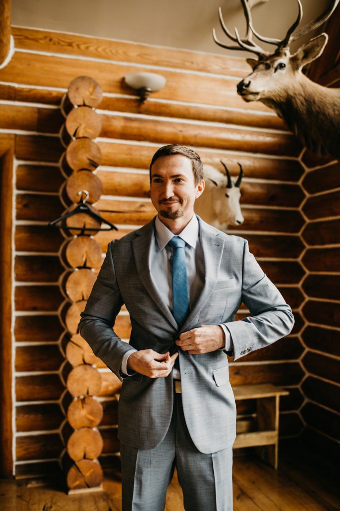 Groom gets ready in a log cabin at the Sixty Chapel in Garden Valley Idaho