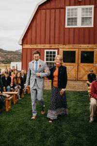 Groom and his mother walk down the aisle together on wedding day