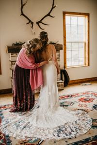Bride's mom zips up Bride's wedding dress moments before she walks down the aisle at the Sixty Chapel in Garden Valley Idaho