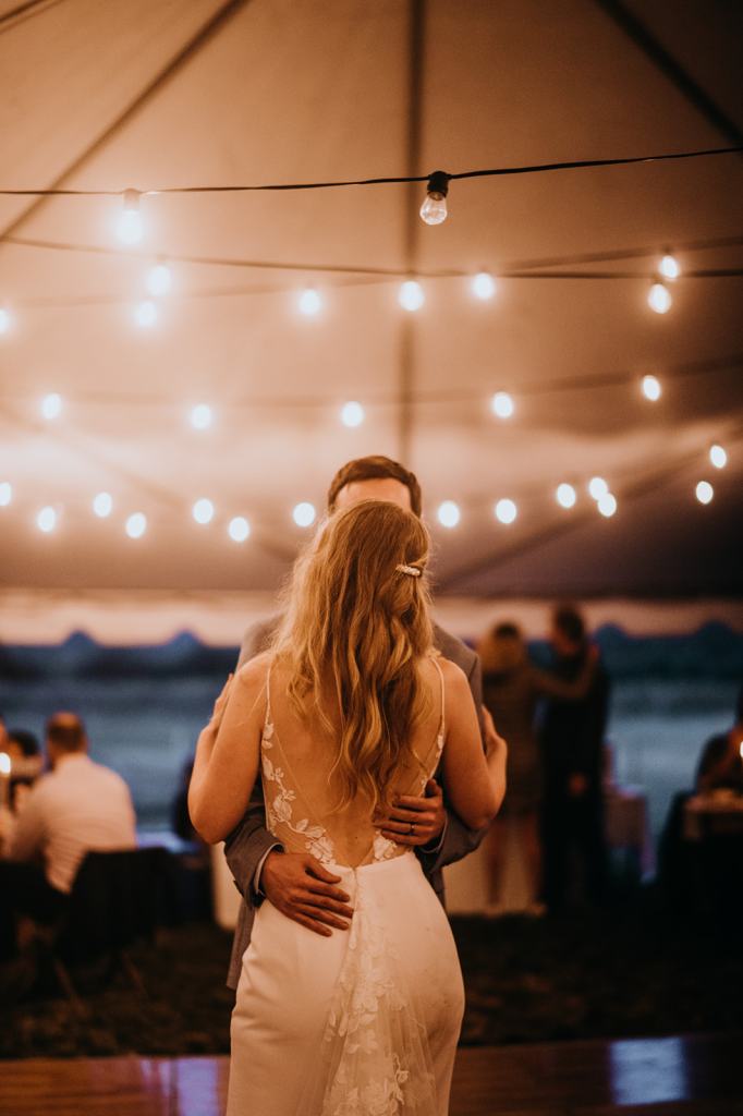 Bride and Groom share their first dance on their wedding day under reception tent at the Sixty Chapel in Garden Valley Idaho