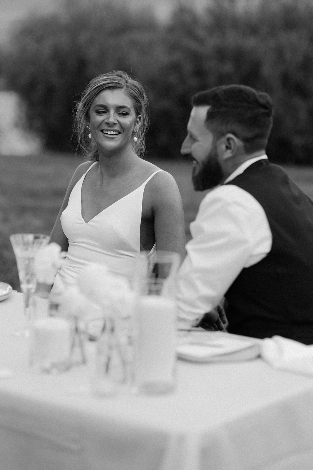 candid moment of bride and groom at their reception laughing on their wedding day in Stanley Idaho