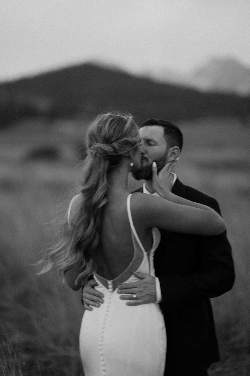 Black and white photo of a bride and groom kissing at sunset in Stanley Idaho on their wedding day