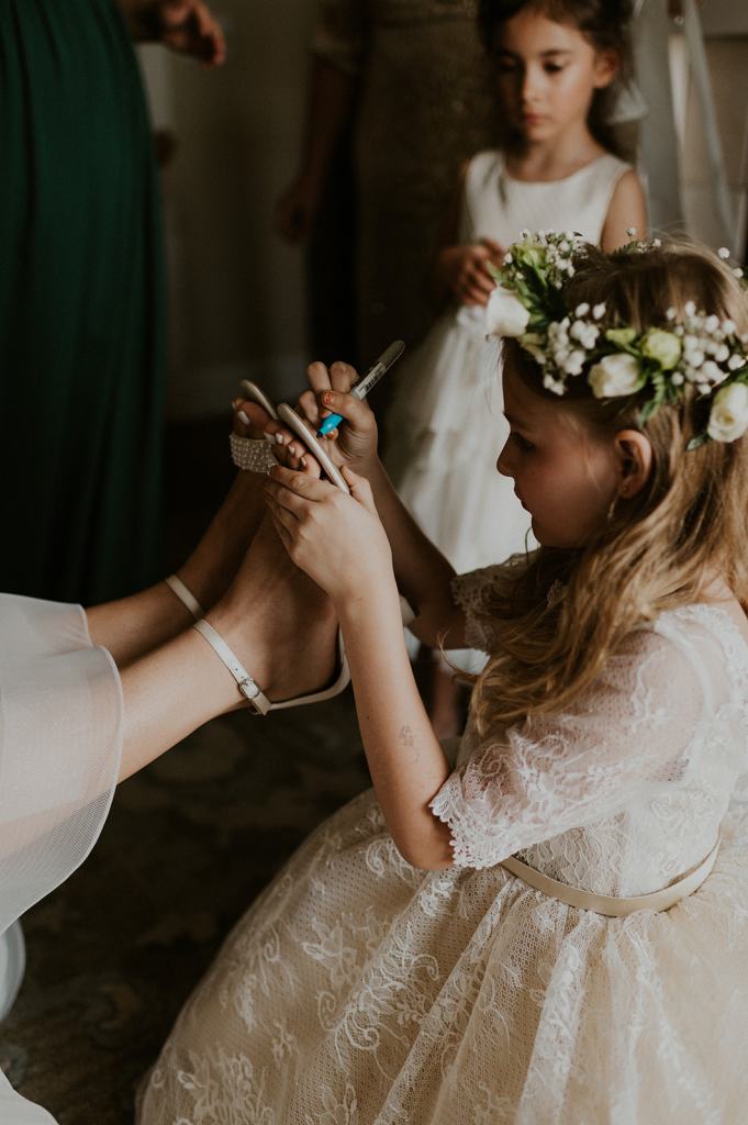 Unique Wedding Day Ideas: flower girl writes message on bride's shoe
