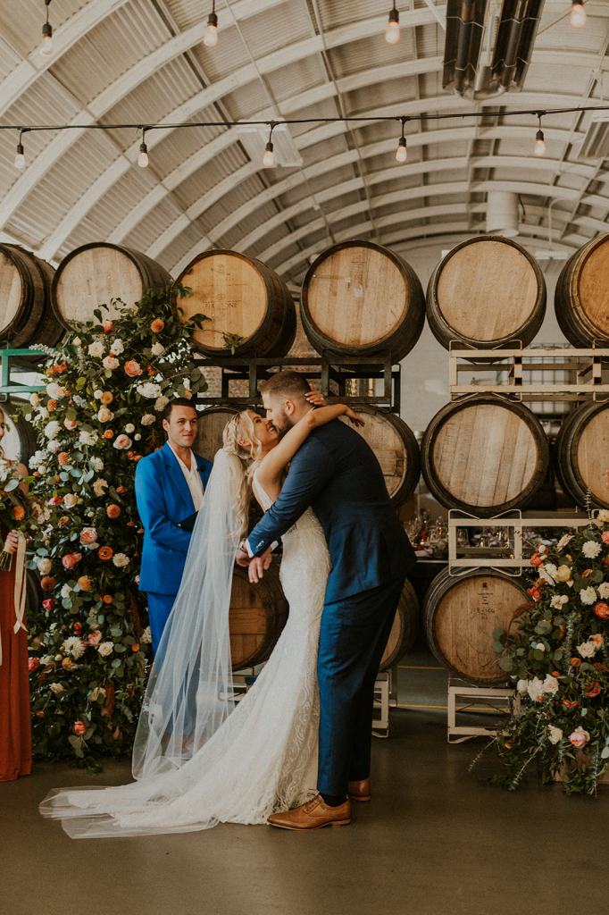First kiss between bride and groom after being pronounced husband and wife in Portland Oregon downtown winery wedding venue