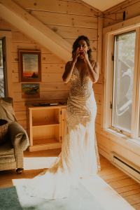 bride gets dressed on her wedding day inside woodsy cabin in McCall Idaho