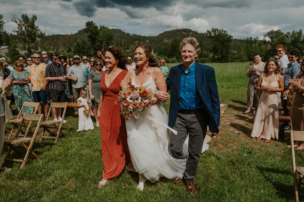 Bride's mother and father walk her down the aisle